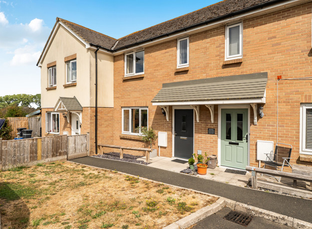Front elevation of modern two-bedroom terraced house with private garden and parking