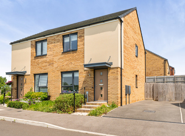 Semi-detached house with driveway, small front garden, and side access gate.