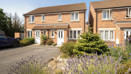 A semi-detached house house with a landscaped front garden and driveway.