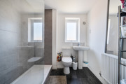 Bathroom with bath, shower, toilet and heated towel rail.