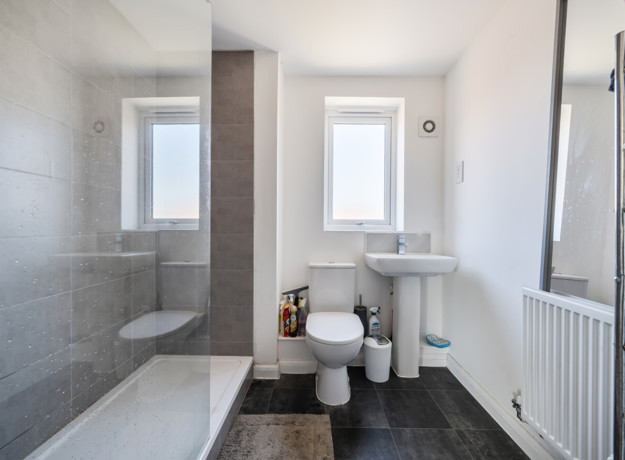 Bathroom with bath, shower, toilet and heated towel rail.
