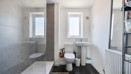 Bathroom with bath, shower, toilet and heated towel rail.