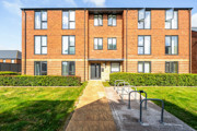 Apartment building with brick exterior, pathway, and bicycle racks.