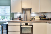 Kitchen worktop with built-in oven, extractor hood and countertop appliances.