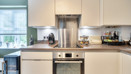 Kitchen worktop with built-in oven, extractor hood and countertop appliances.