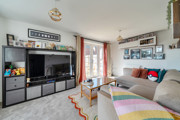 Living room with corner sofa, television unit and patio doors.