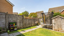 Garden with a lawn, paved path, fencing, trampoline and wooden shed.