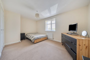 Spacious double bedroom with bed, chest of drawers and neutral decor