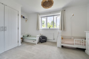 Bedroom with built-in wardrobes, two children's beds and a window.