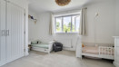 Bedroom with built-in wardrobes, two children's beds and a window.