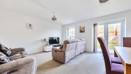 Living room with sofas, TV, dining table, and doors to the garden.