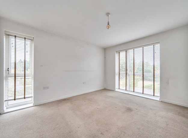 Bedroom with carpet and floor-to-ceiling windows.