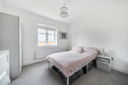 Bedroom with double bed, bedside table, window, and light grey decor.