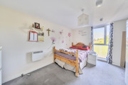 Bedroom with bed, desk area and window bringing in natural light