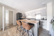 Kitchen with breakfast bar, stools and integrated appliances.