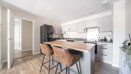 Kitchen with breakfast bar, stools and integrated appliances.