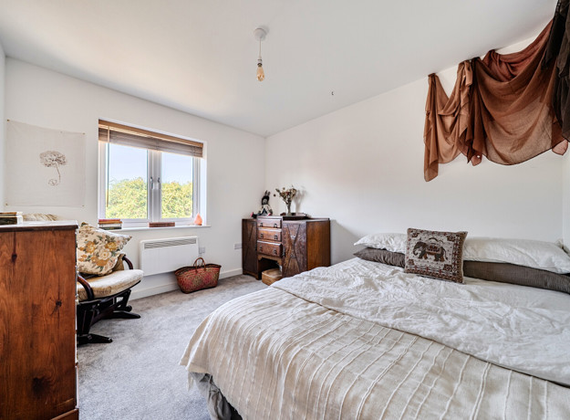 Bedroom with double bed, wooden furniture and window.