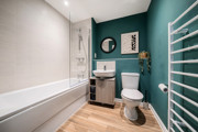 Bathroom with bath, toilet, sink unit and towel rail.