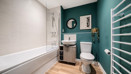 Bathroom with bath, toilet, sink unit and towel rail.