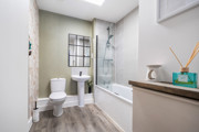 Bathroom with bathtub, shower screen, toilet, and sink.