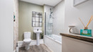 Bathroom with bathtub, shower screen, toilet, and sink.