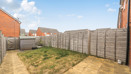 Rear garden with lawn, patio area, shed and fenced boundaries.
