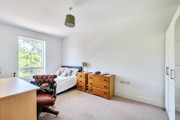 Bedroom with a bed, window, chest of drawers, and desk.