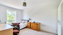 Bedroom with a bed, window, chest of drawers, and desk.