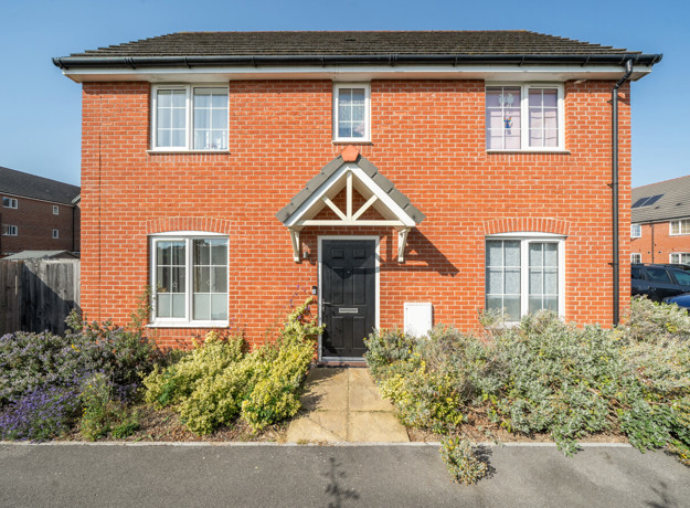 Detached brick house with a front garden and path leading to the entrance.