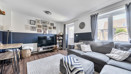 Living room with sofas, tv, windows and a door into back garden.