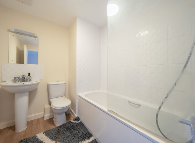 Bathroom with bathtub, shower screen, toilet and pedestal sink