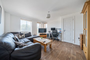 Living and dining area with wood flooring and access to the hallway.