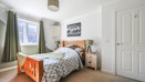 Double bedroom with wooden bed frame, bedside tables, door and window
