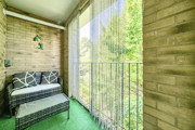 Balcony with seating and railings overlooking trees.