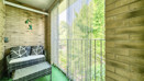 Balcony with seating and railings overlooking trees.
