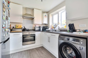 Kitchen with fitted units, appliances, washing machine and window.