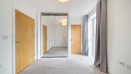 Carpeted bedroom with wooden doors, wardrobe with mirrored sliding doors and a ceiling light