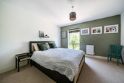 Bedroom with a double bed, bedside tables, framed wall art and window.