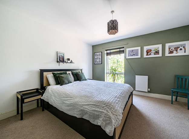 Bedroom with a double bed, bedside tables, framed wall art and window.