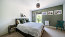 Bedroom with a double bed, bedside tables, framed wall art and window.