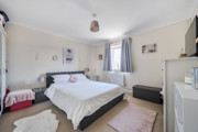 Bedroom with a double bed, wardrobe, window and chest of drawers.