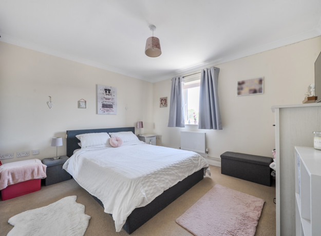Bedroom with a double bed, wardrobe, window and chest of drawers.