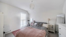 Bedroom with double bed, bedside drawers, and window with white blinds.