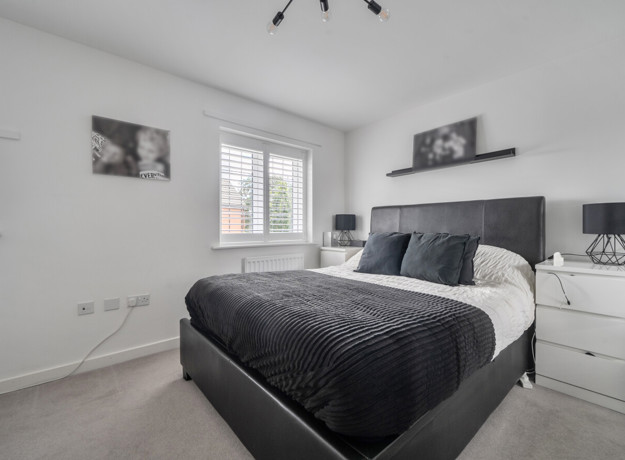 Bedroom with double bed, bedside tables, and neutral walls.