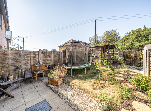 Rear garden with patio, lawn, fencing and outdoor seating area.
