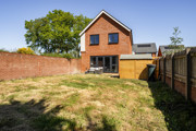 Rear garden with lawn, fenced boundaries and detached house exterior