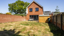 Rear garden with lawn, fenced boundaries and detached house exterior