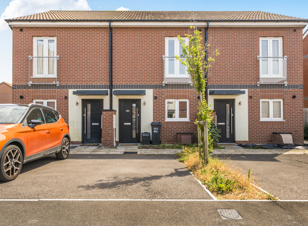 Two-storey red brick house with driveway parking and a small front garden.
