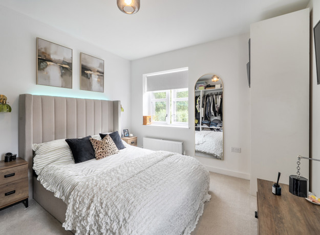 Bedroom with double bed, bedside tables, window and wall-mounted television.