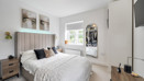 Bedroom with double bed, bedside tables, window and wall-mounted television.